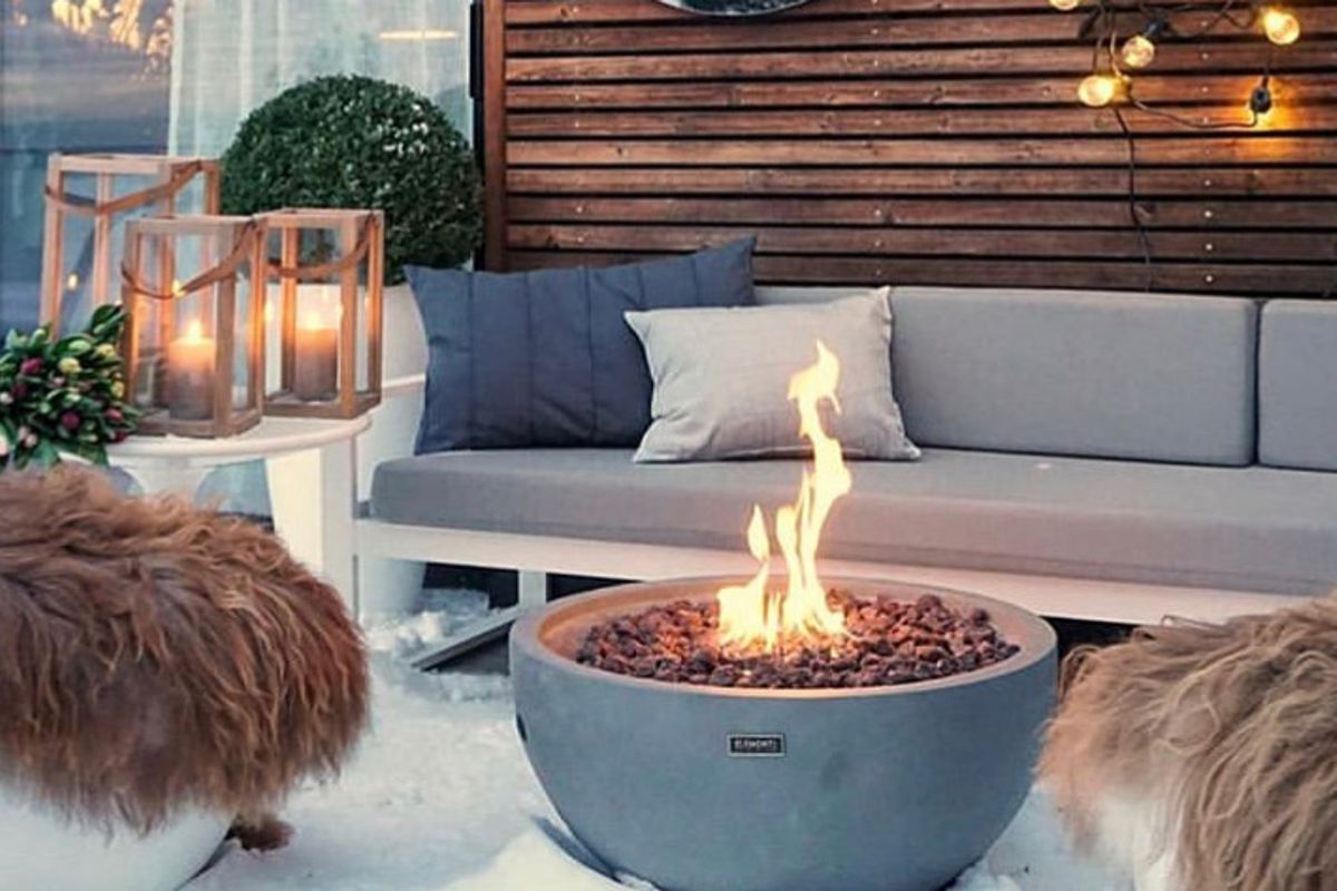 Feuerstelle NANTUCKET mit brennendem Feuer vor einem Gartensofa