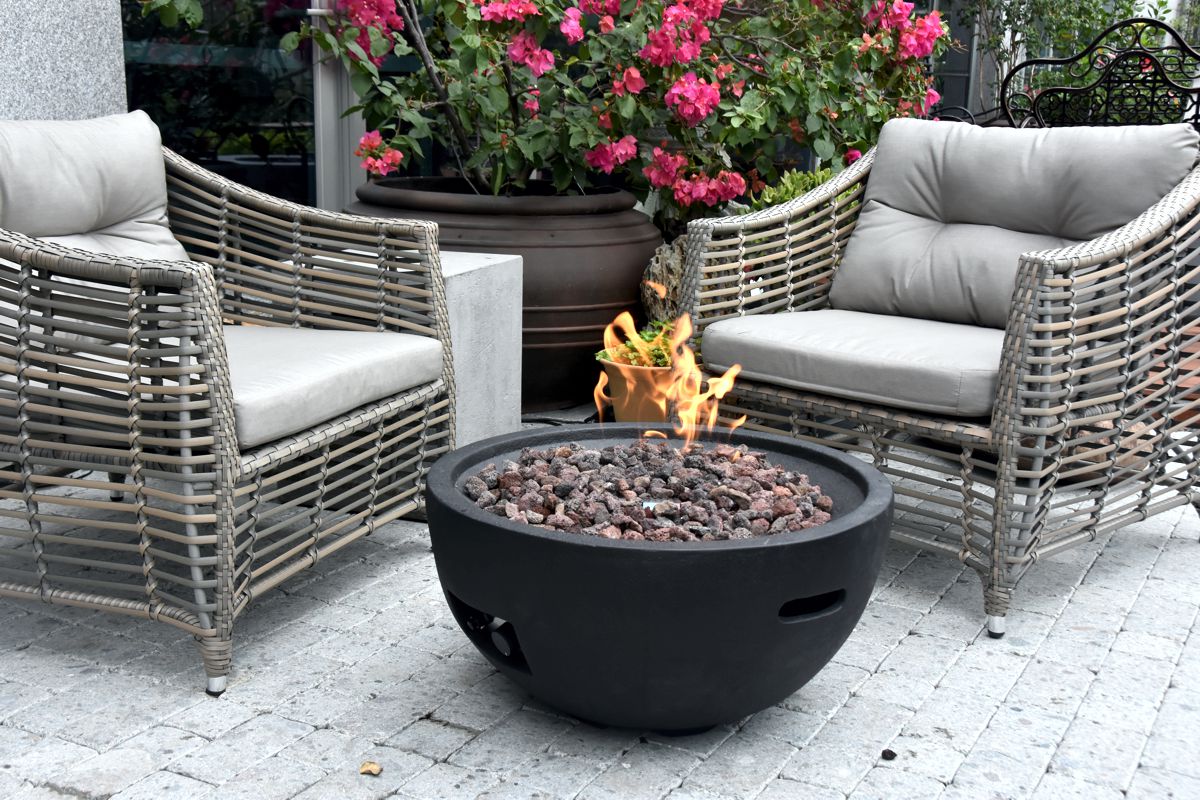 Feuerstelle JEFFERSON mit brennendem Feuer zwischen Gartensesseln