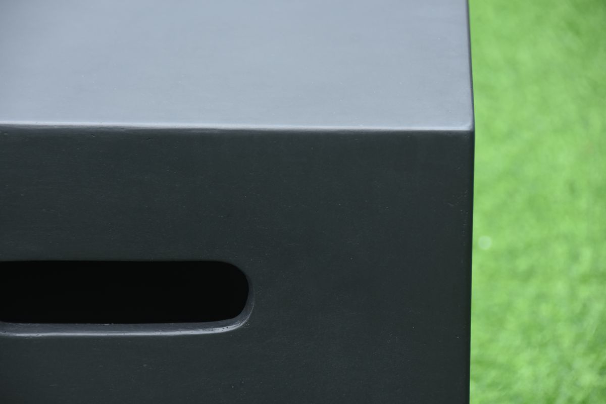 Schwarze Flaschenabdeckung neben einer dunklen Feuerstelle