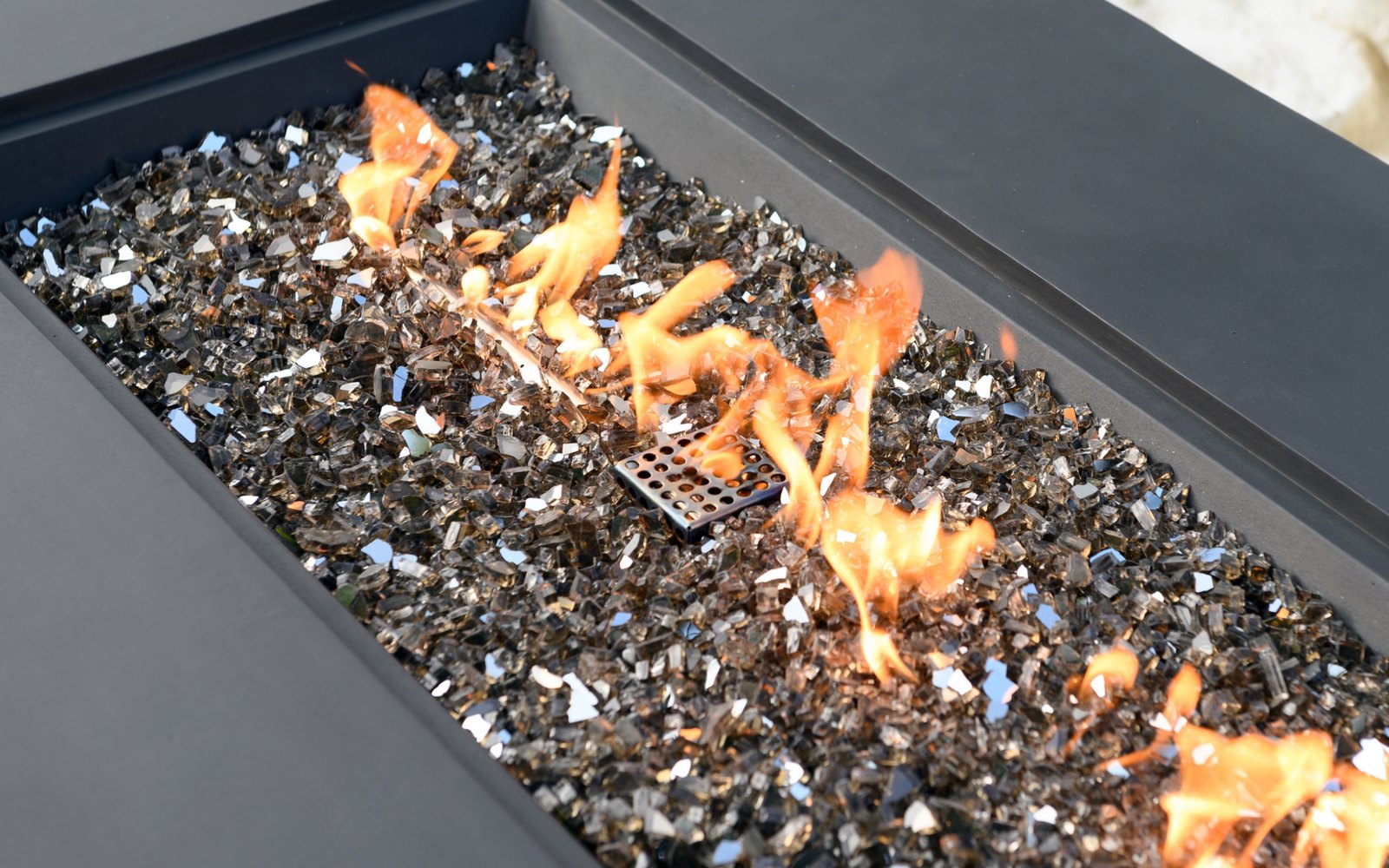 Bronzefarbenes Dekorglas in einer brennenden Feuerstelle