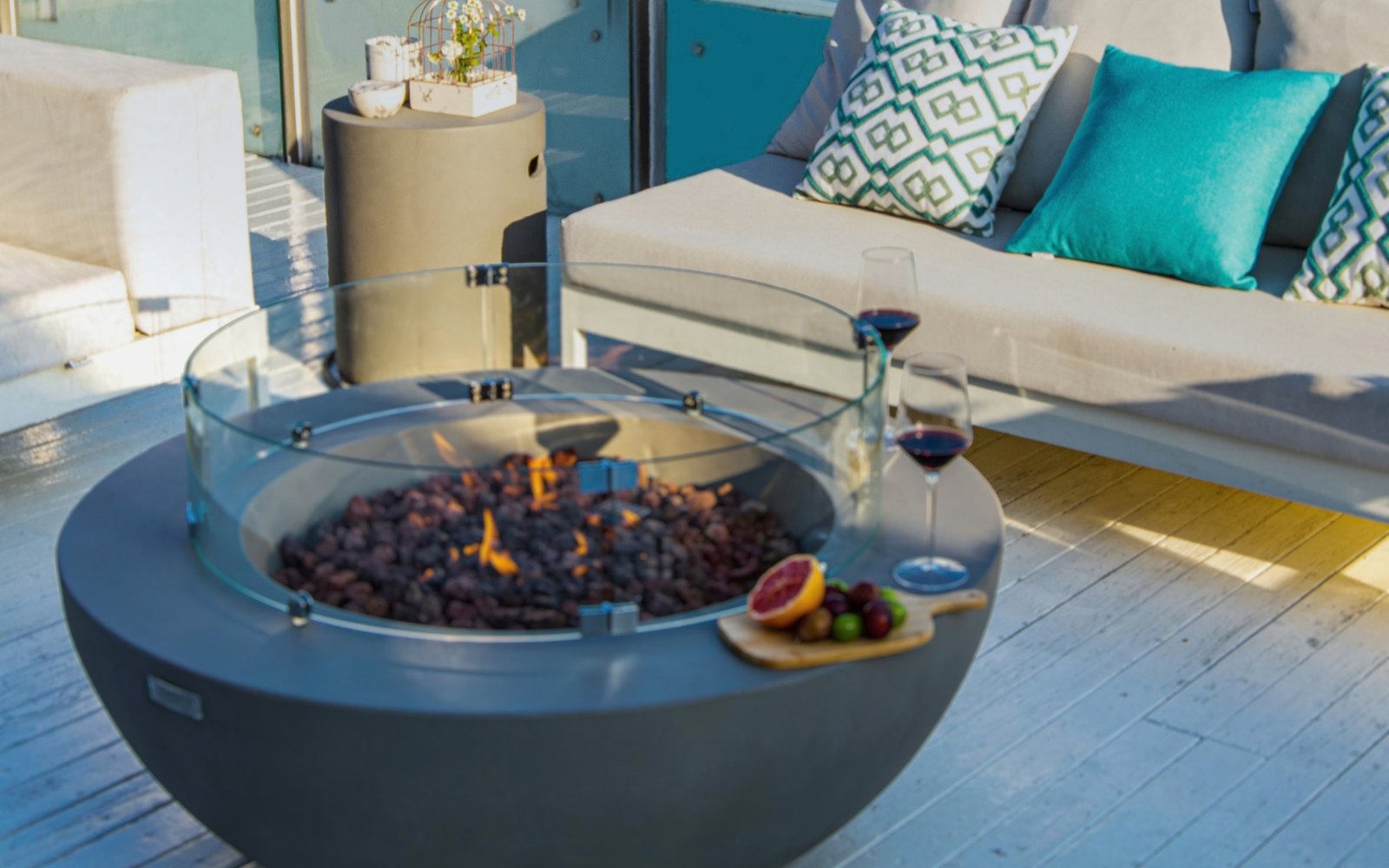 Runde Flaschenabdeckung neben der Feuerstelle LUNAR BOWL auf der Terrasse