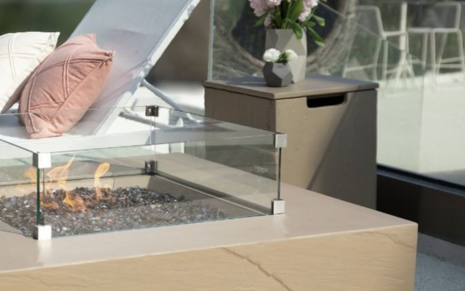 Flaschenabdeckung in Sandsteindekor neben einer Feuerstelle mit Glasschutz