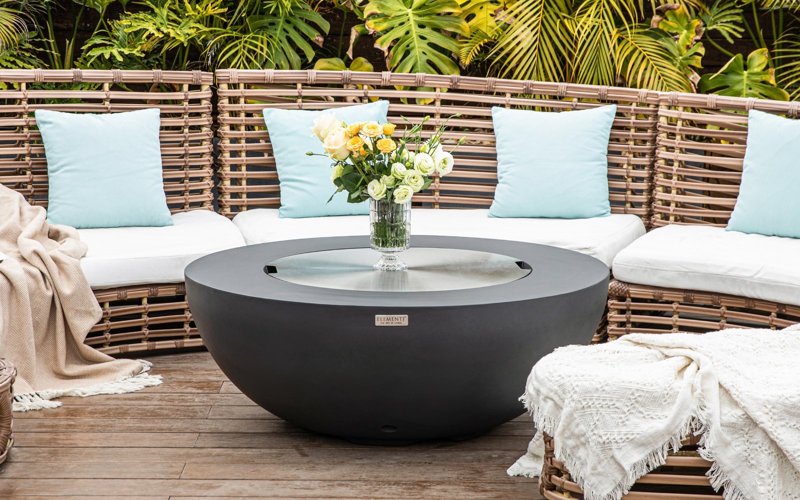 Feuerstelle LUNAR BOWL mit Edelstahlabdeckung und Blumenstrauß auf der Terrasse