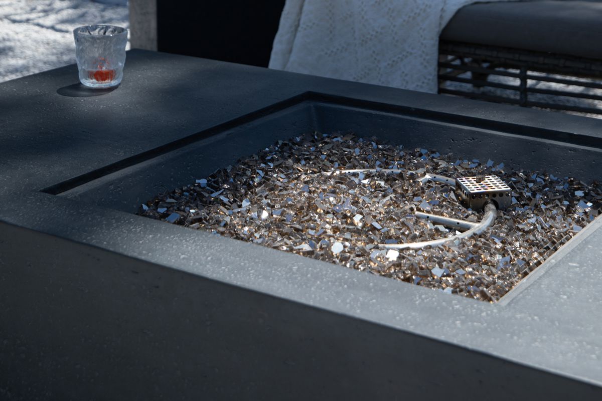Detail des Tisches CANNES mit Dekorglas in der Feuerstelle