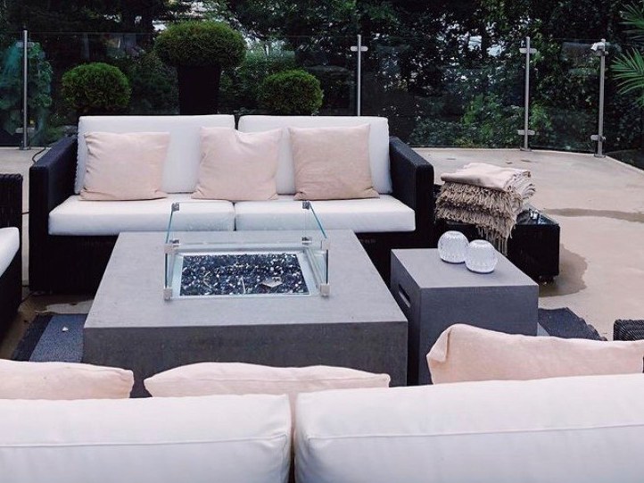 Tisch LISMORE mit Windschutz aus Glas zwischen Sofas
