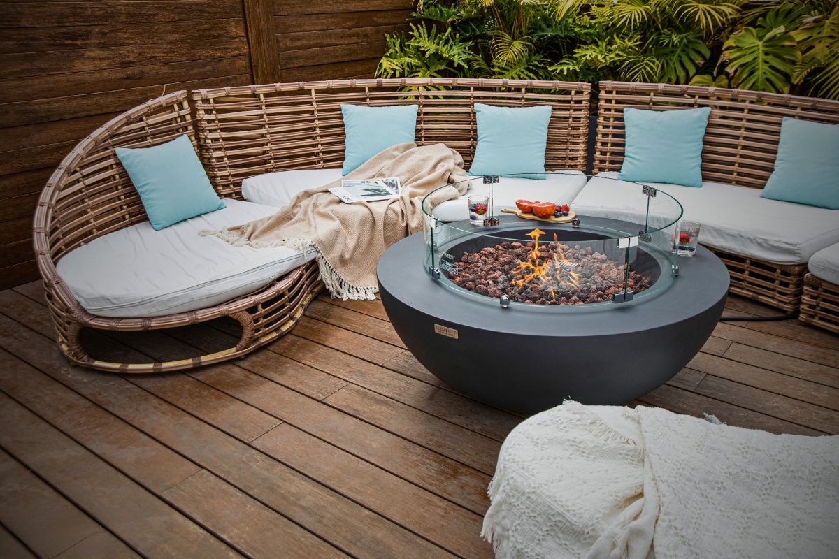 Feuerstelle LUNAR BOWL Dark Grey auf der Terrasse vor einem runden Sofa