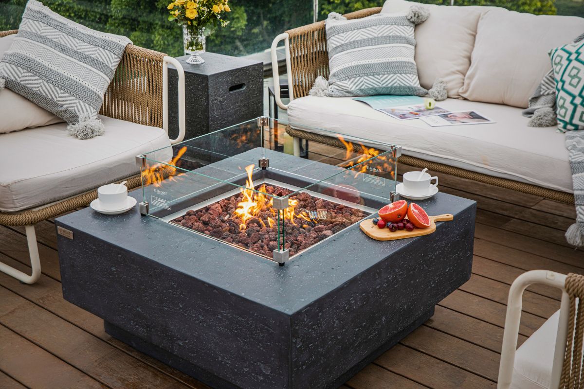 Tisch MANHATTAN Dark Grey mit Windschutz aus Glas und Flaschenabdeckung auf der Terrasse