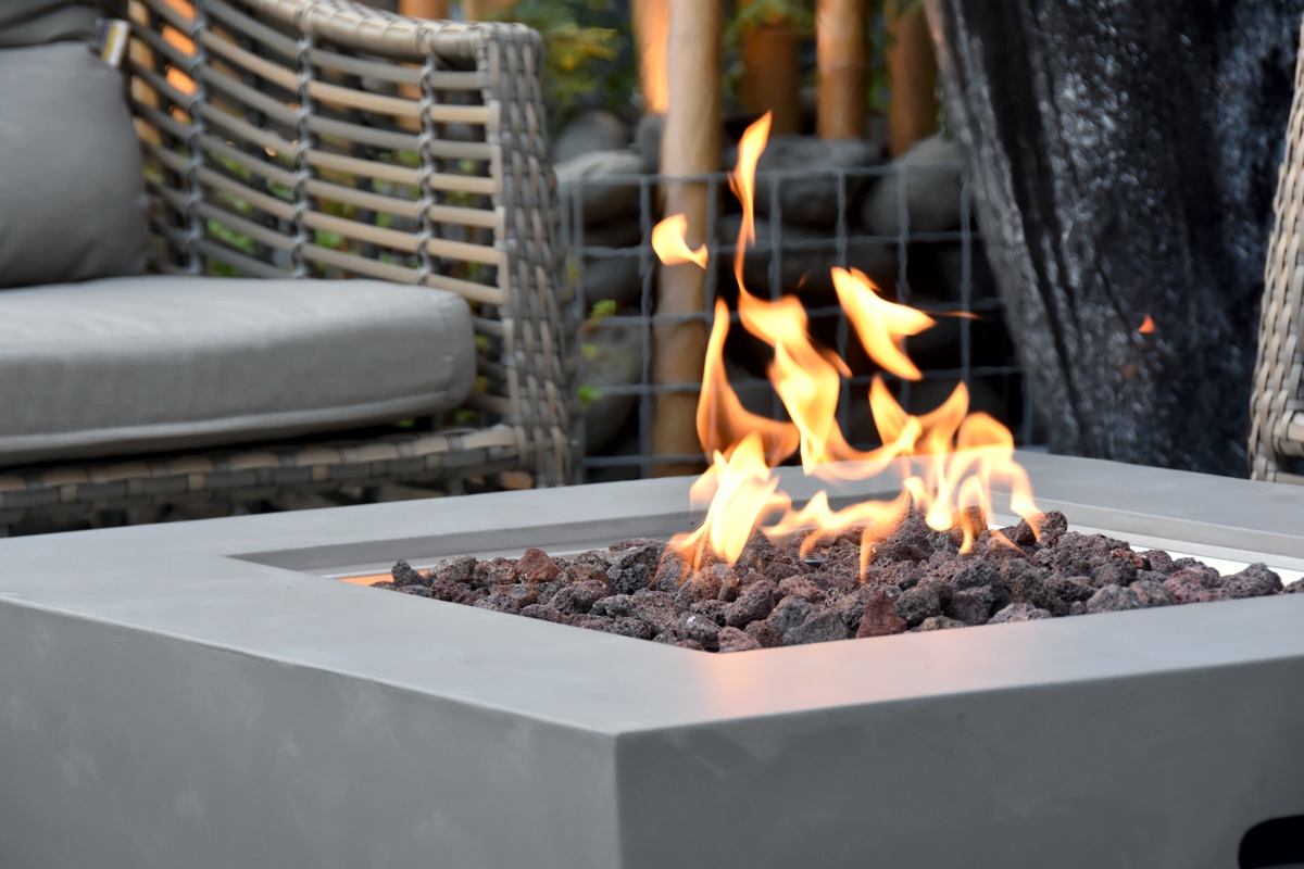 Die Flamme über den Lavasteinen in der Feuerstelle des Tisches WESTPORT