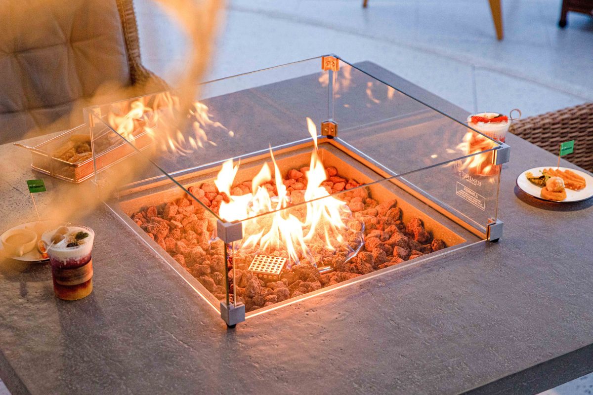 Feuerstelle des Tisches BIRMINGHAM mit Windschutz aus Glas