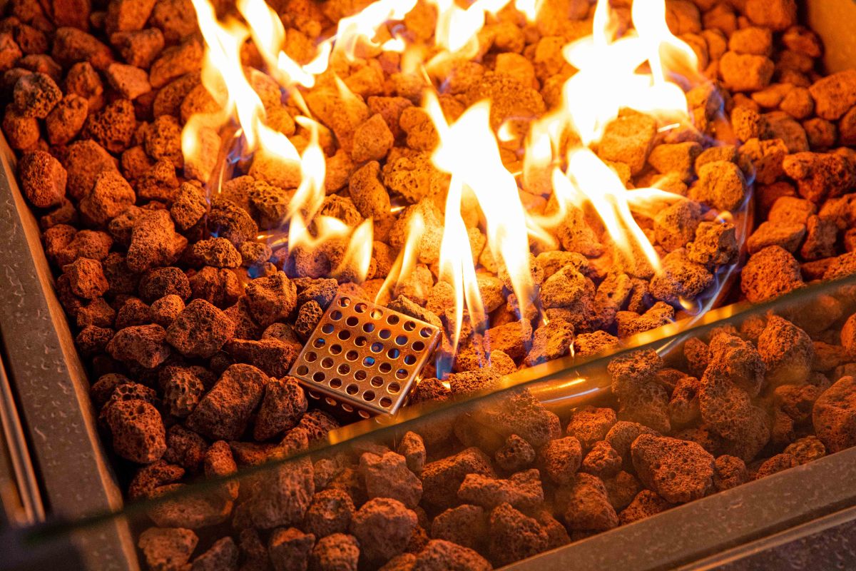 Die Flamme über den Lavasteinen in der Feuerstelle des Tisches BIRMINGHAM