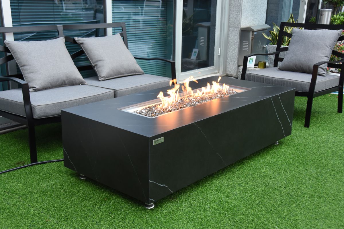 Tisch VARNA mit brennendem Feuer auf der Terrasse vor einem Sofa