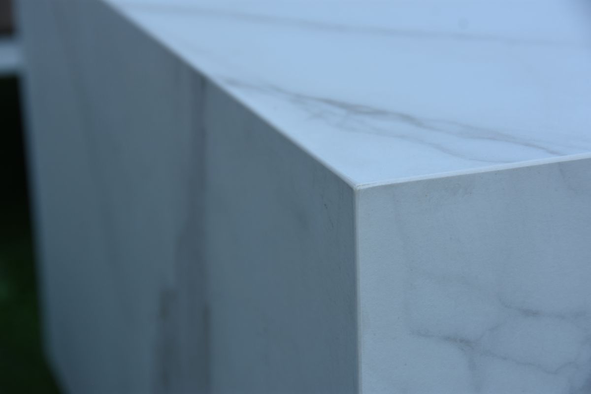 Kante des Tisches CARRARA im Dekor Carrara-Marmor aus der Nähe
