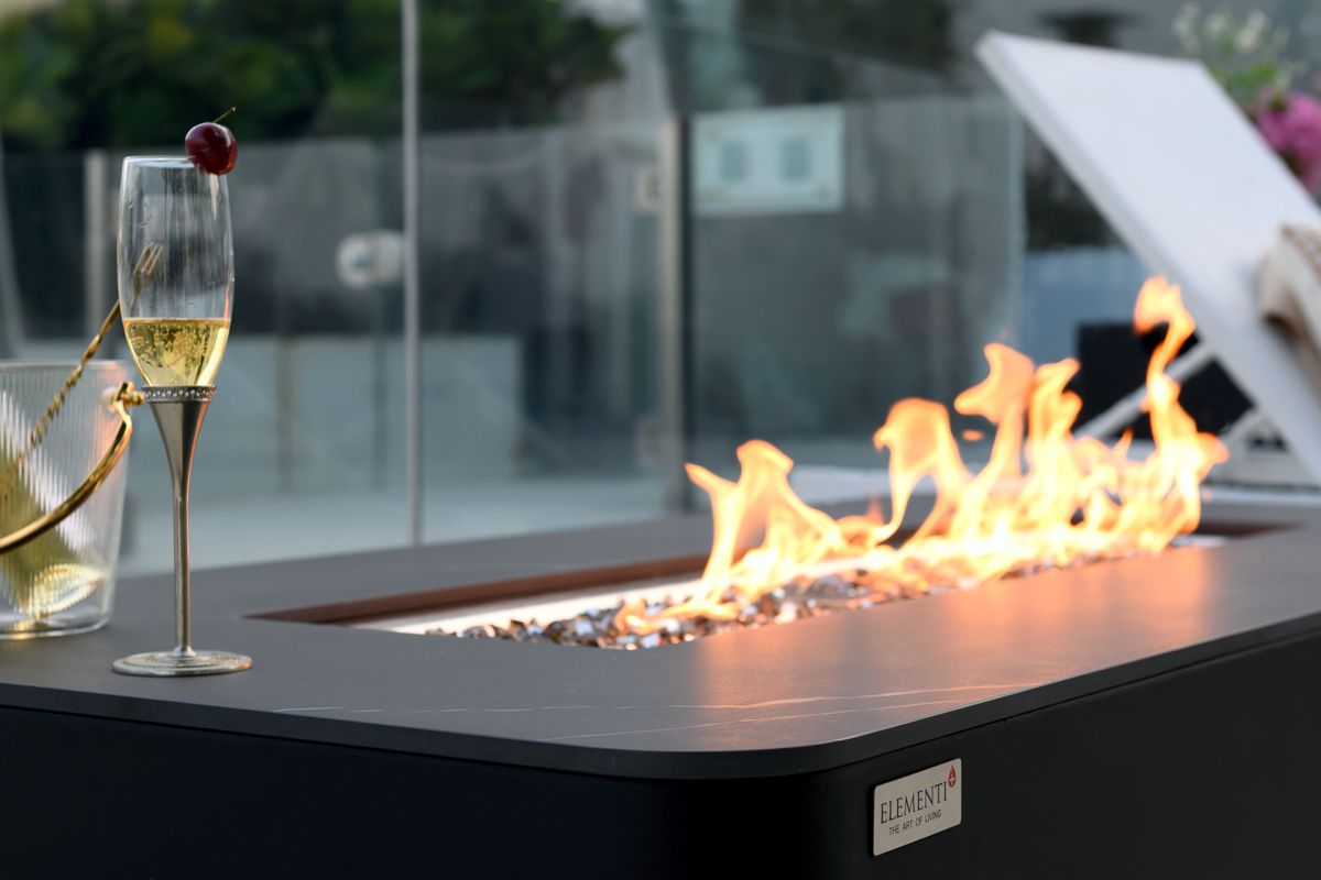 Die Flamme in der Feuerstelle des Tisches VALENCIA aus der Nähe